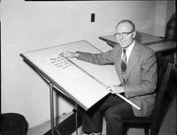 A picture of a Mankato State College professor sitting at a drafting table, 1960s.
