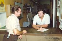 Two men talking at a counter, Mankato State University, 1987.